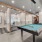 Clubhouse billiards table with private work-from-home office rooms in the background at Hermann Park Lofts.