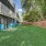 Fenced dog park with artificial turf and shaded trees at pet-friendly Hermann Park Lofts.