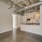Apartment kitchen with granite countertops, pendant lighting, and exposed industrial ceiling at Hermann Park Lofts.