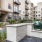 Outdoor kitchen with egg-style grill, sink, and seating surrounded by greenery at Hermann Park Lofts, an apartment community in Houston’s Museum District.