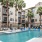 Resort-style swimming pool with lounge chairs, cabana seating, and palm trees at Hermann Park Lofts in Houston’s Museum District.