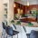 Modern kitchen with granite countertops, wood cabinetry, and breakfast bar seating at Hermann Park Lofts.