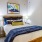 Bedroom with modern bed, blue pillows, and stylish lighting at Hermann Park Lofts.